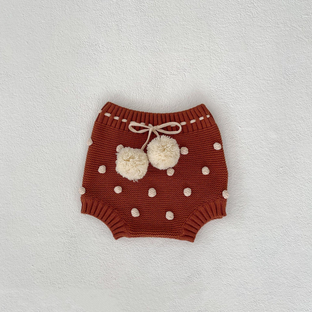 Children's knitted shorts with pompoms.